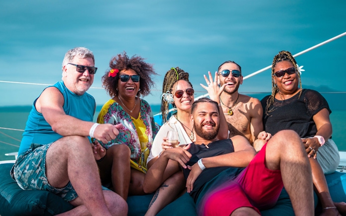 Group enjoying Sabre Sunset Cruise with BBQ dinner and drinks on a boat.