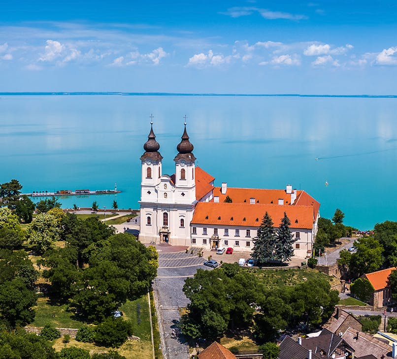 Sailboats on Lake Balaton, Hungary, with lush green hills in the background.