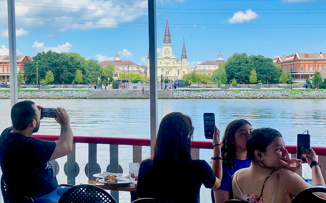 People photographing the view of St. Louis Cathedral from Steamboat Natchez in New Orleans.