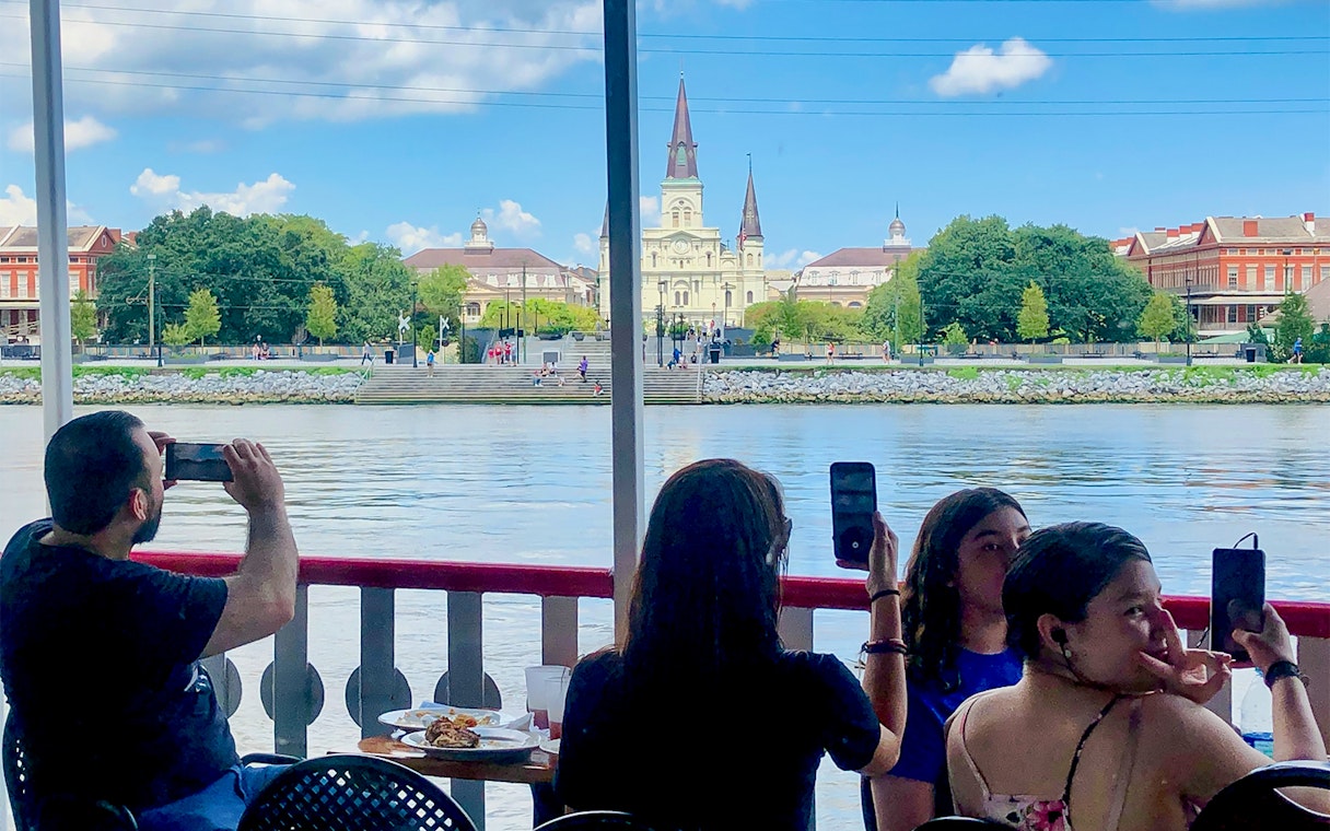 People photographing the view of St. Louis Cathedral from Steamboat Natchez in New Orleans.