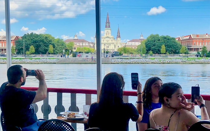 People photographing the view of St. Louis Cathedral from Steamboat Natchez in New Orleans.