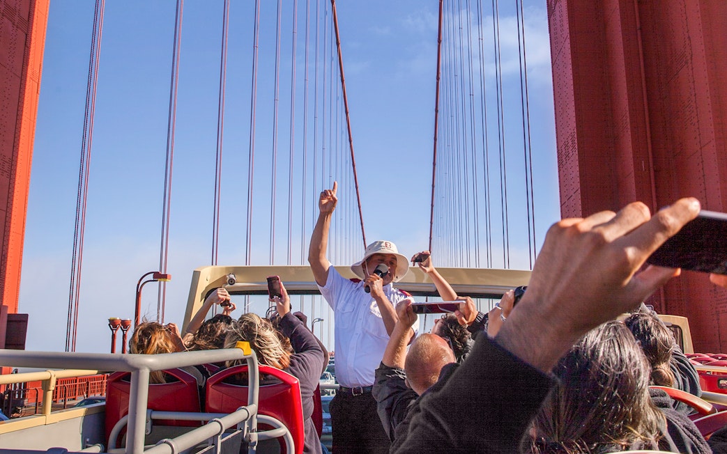 Open-top bus tour crossing Golden Gate Bridge with live guide in San Francisco.