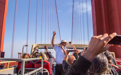 Open-top bus tour crossing Golden Gate Bridge with live guide in San Francisco.