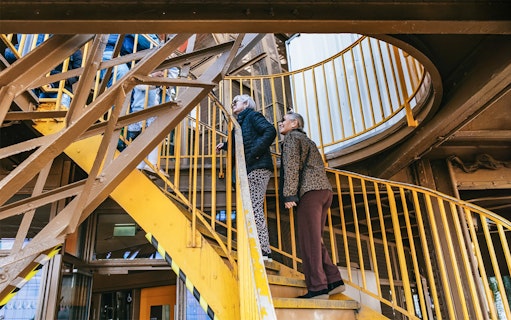 Visitors ascending Eiffel Tower stairs during guided tour in Paris.