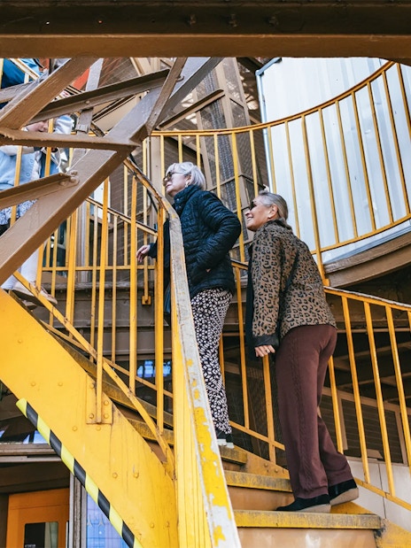Visitors ascending Eiffel Tower stairs during guided tour in Paris.