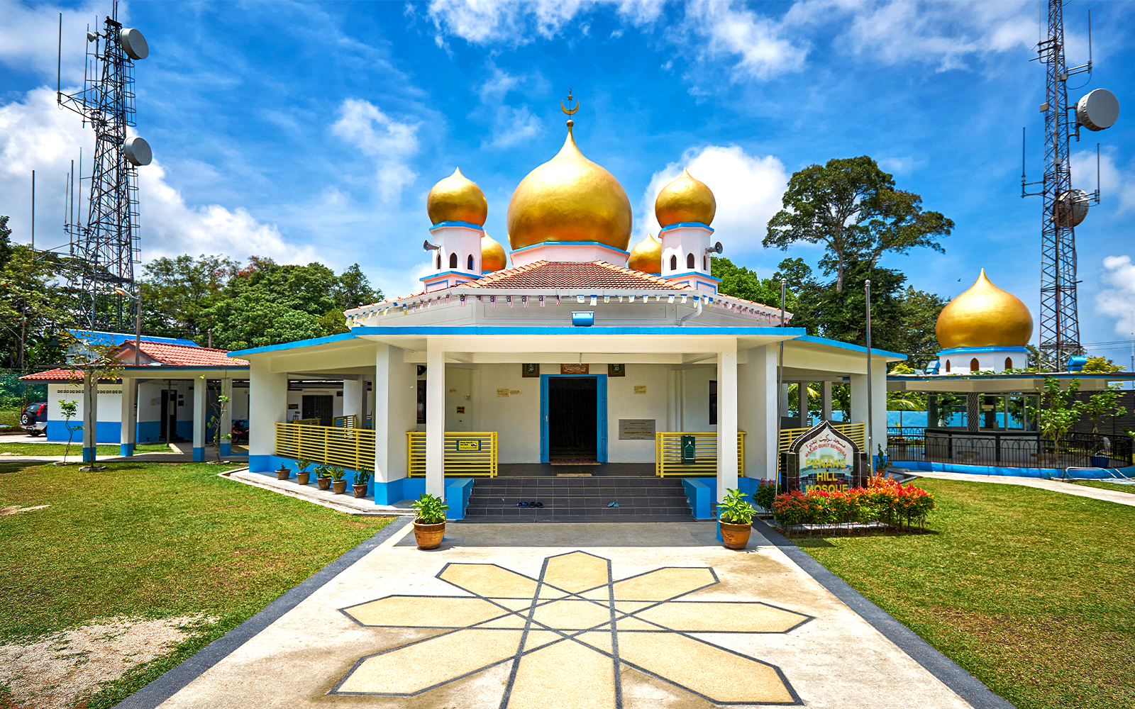 View of Penang Hill Mosque at sunset with lush greenery in the foreground, Malaysia