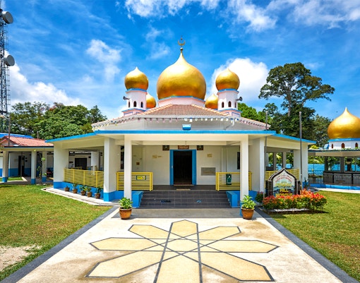 View of Penang Hill Mosque at sunset with lush greenery in the foreground, Malaysia