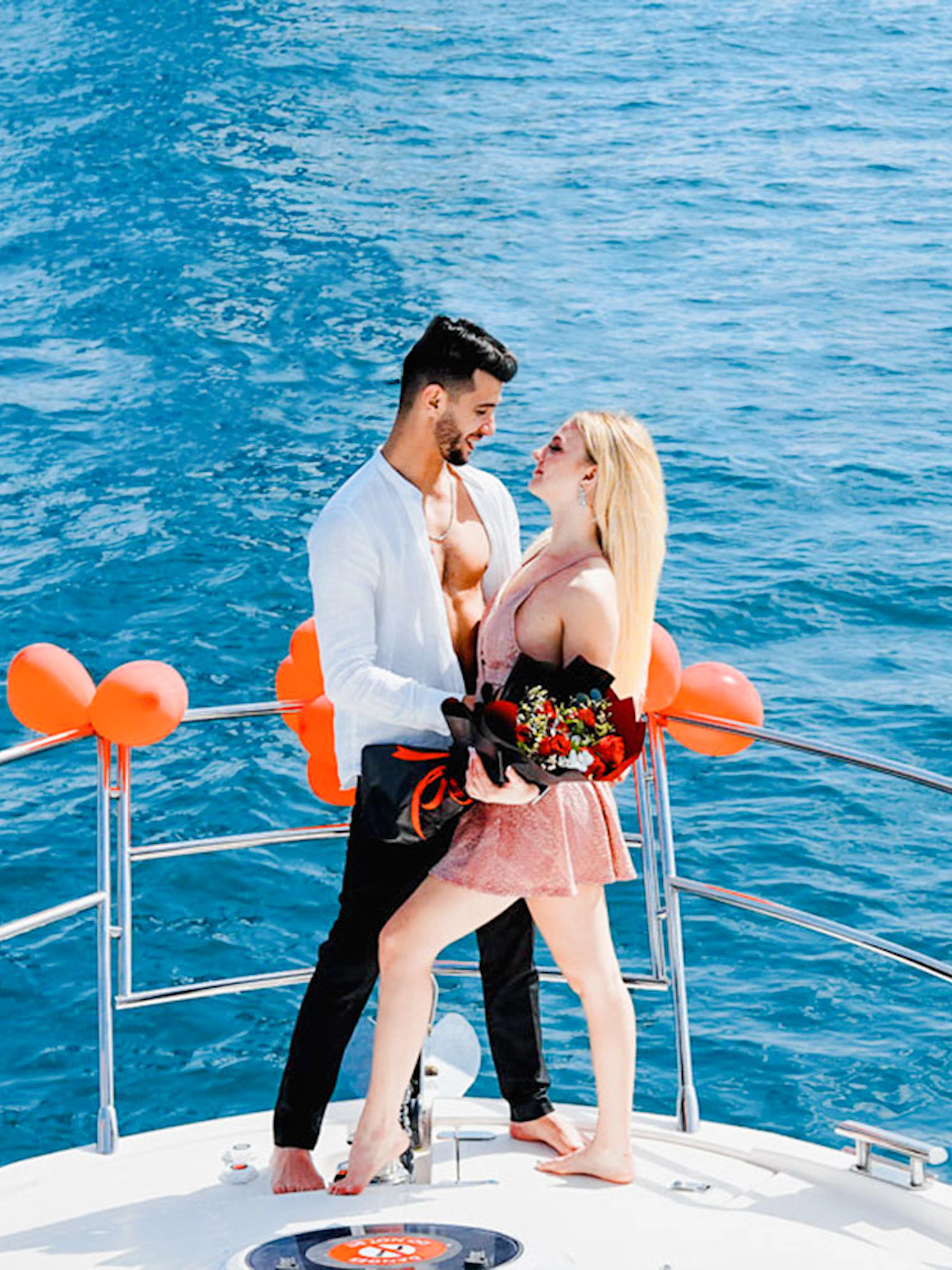 Couple embracing on a private yacht decorated with balloons, Dubai.