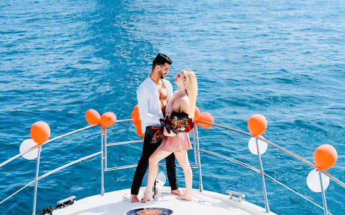 Couple embracing on a private yacht decorated with balloons, Dubai.