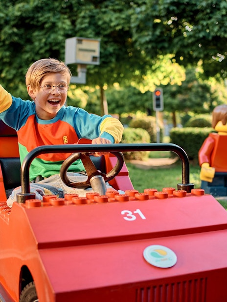 Child driving a LEGO car at LEGO City Driving School, LEGOLAND Windsor Resort.