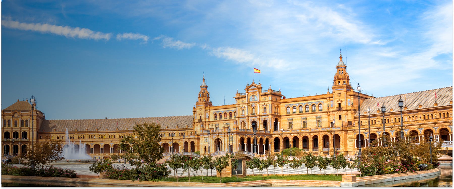 Plaza de España in Seville with fountain and Spanish flag.