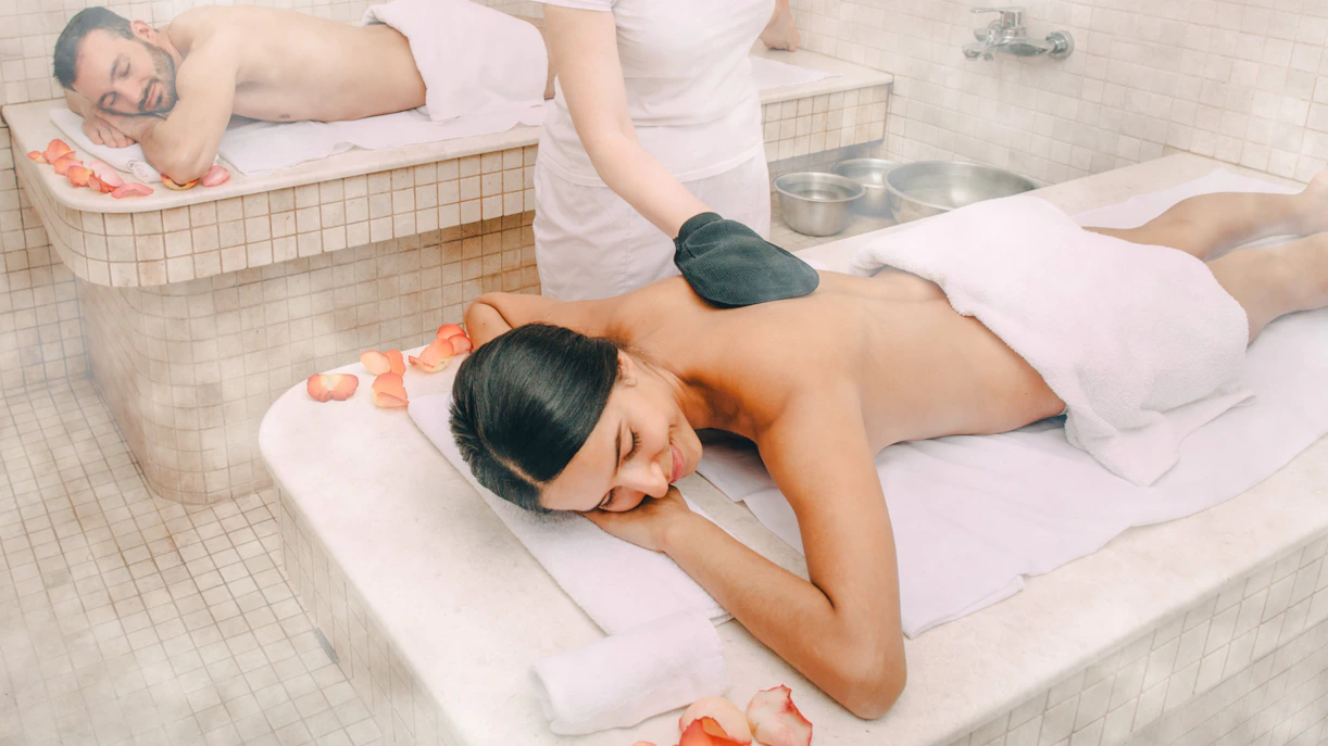 Guests enjoying a Turkish kese scrub in a traditional hammam.