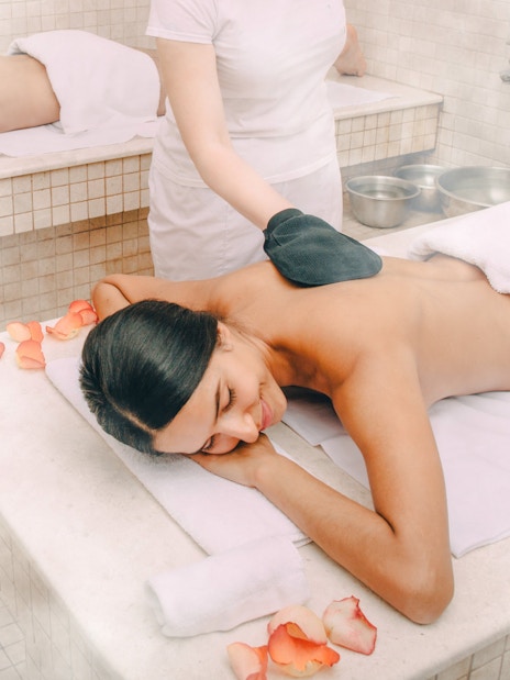 Guests enjoying a Turkish kese scrub in a traditional hammam.