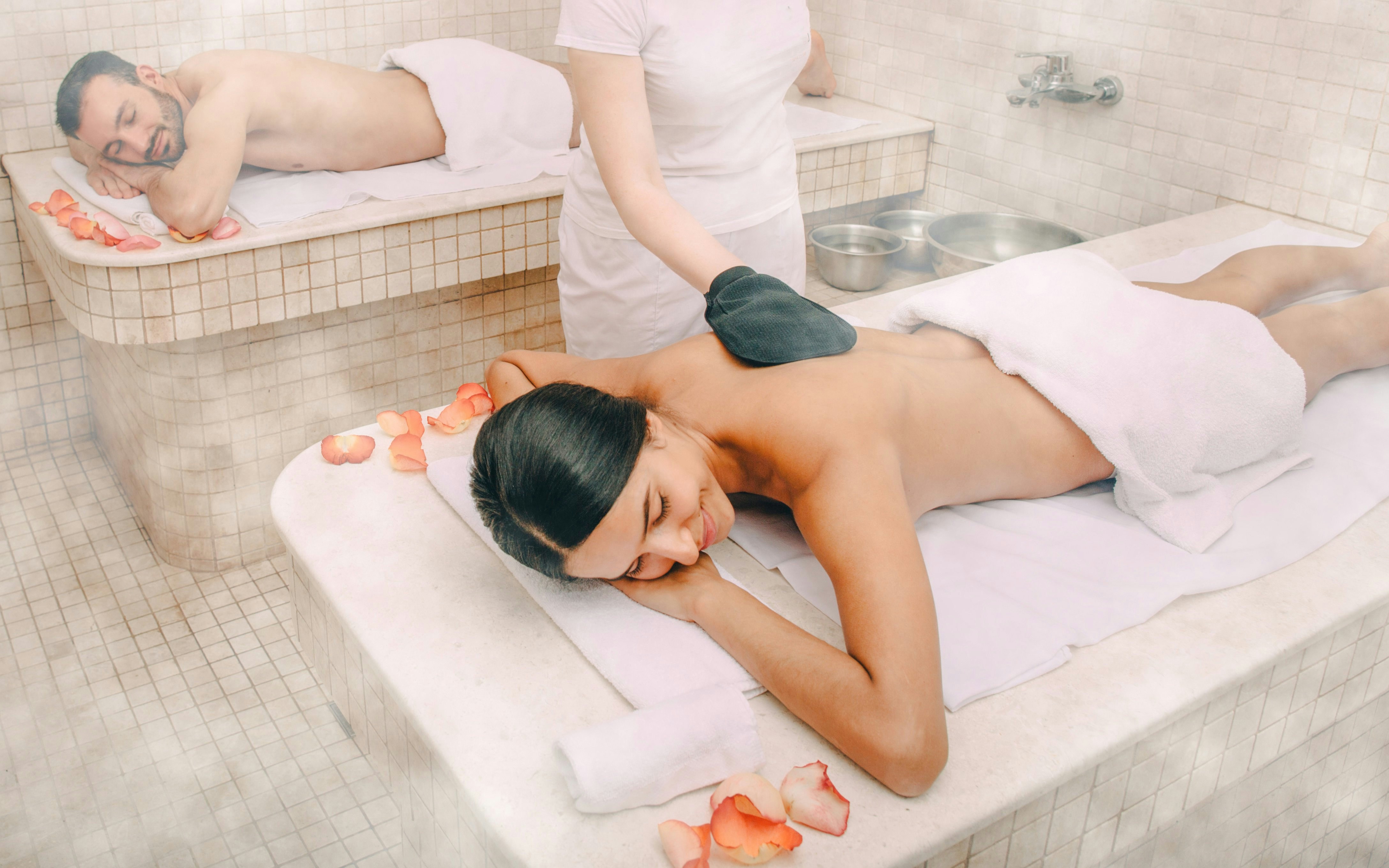 Guests enjoying a Turkish kese scrub in a traditional hammam.