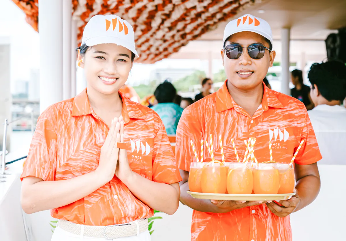 Crew members on Pattaya luxury yacht serving drinks during 3-island cruise.