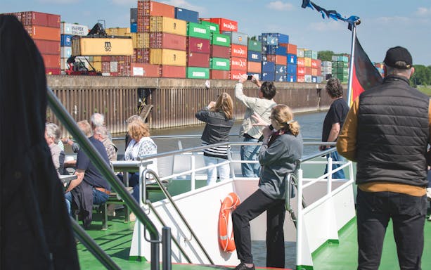Tourists on a boat viewing shipping containers at Cologne Harbour.