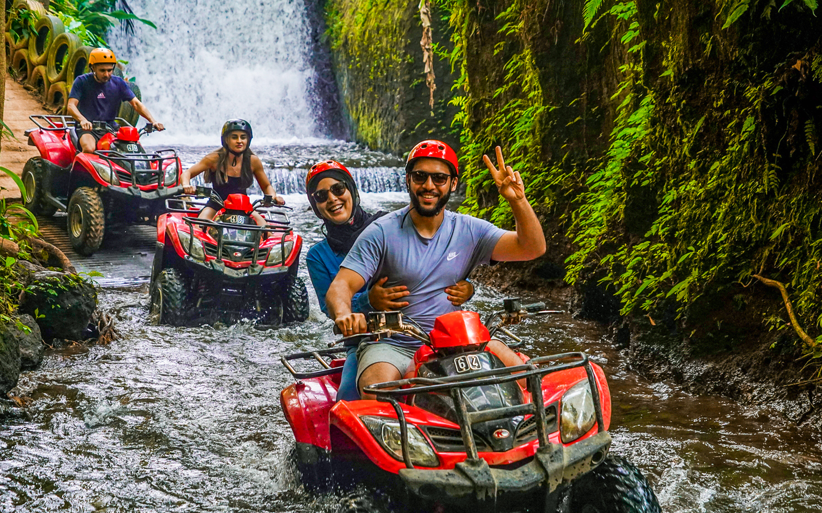 ATV riders navigating a jungle stream near Goa Raja Waterfall in Ubud.