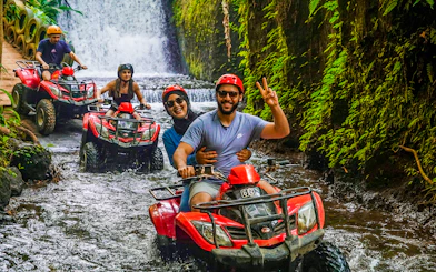 ATV riders navigating a jungle stream near Goa Raja Waterfall in Ubud.