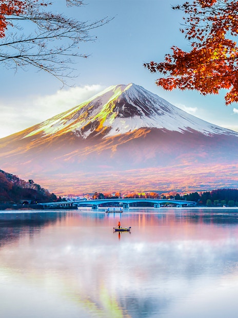 Mount Fuji reflected in Lake Kawaguchi with autumn leaves in the foreground.