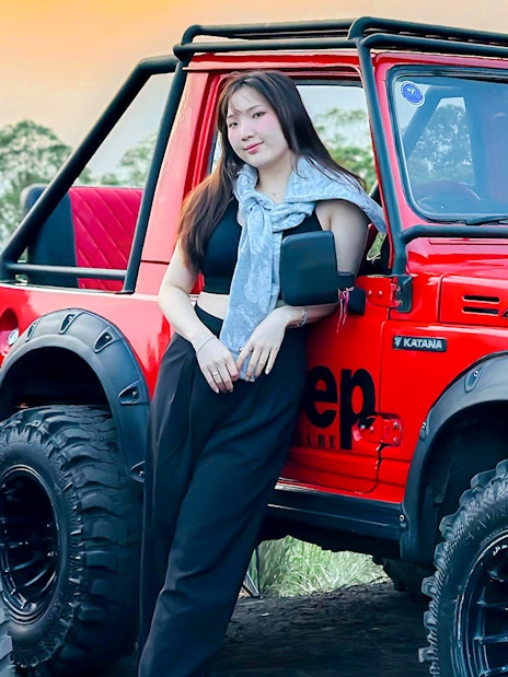 Red Jeep for Mount Batur Sunrise Tour with forest backdrop.