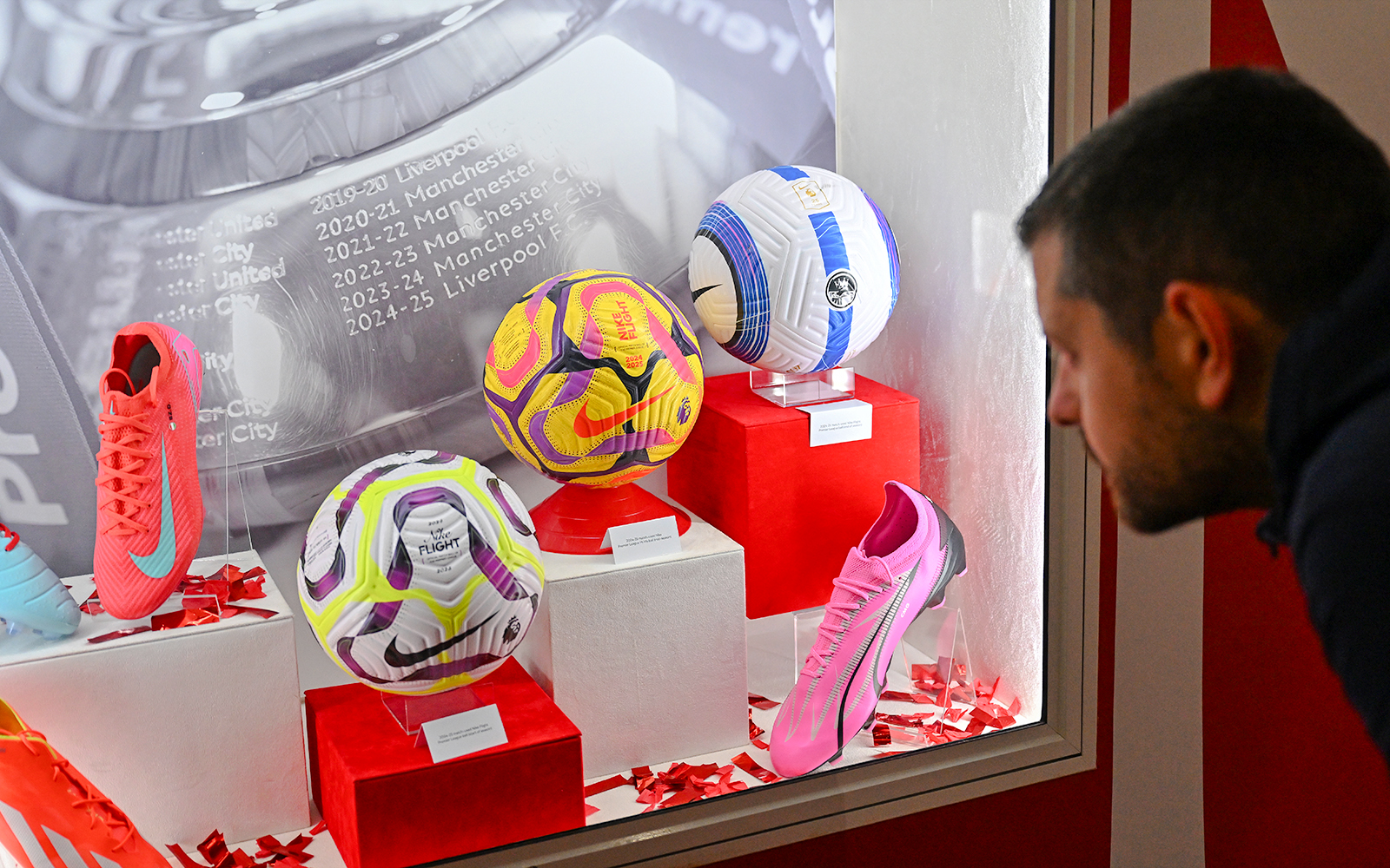 Display of football memorabilia at Liverpool FC Museum, Anfield, featuring balls and boots.