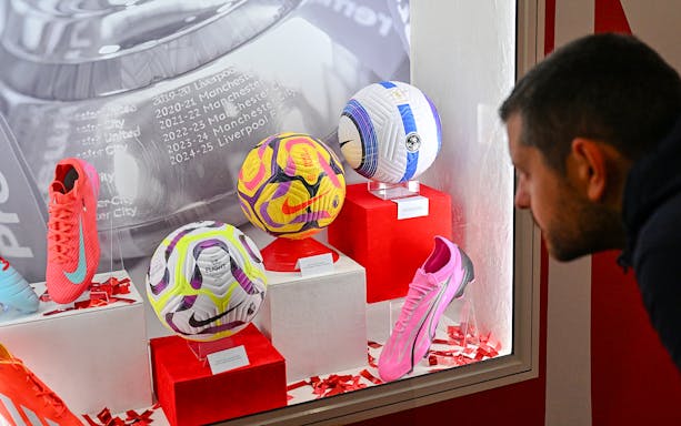 Display of football memorabilia at Liverpool FC Museum, Anfield, featuring balls and boots.