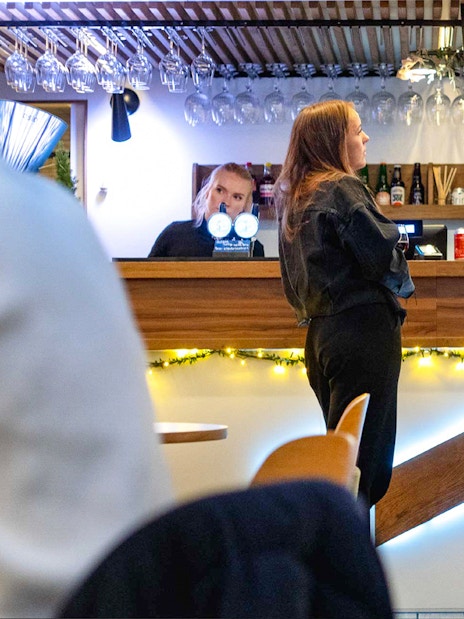 Bar area on Oslo dinner cruise with people enjoying drinks.