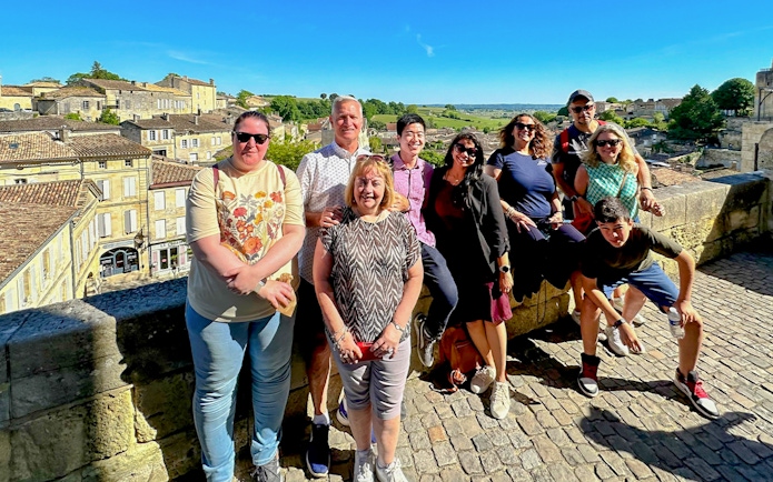 Group enjoying a tour in Saint Emilion with village and vineyard views.