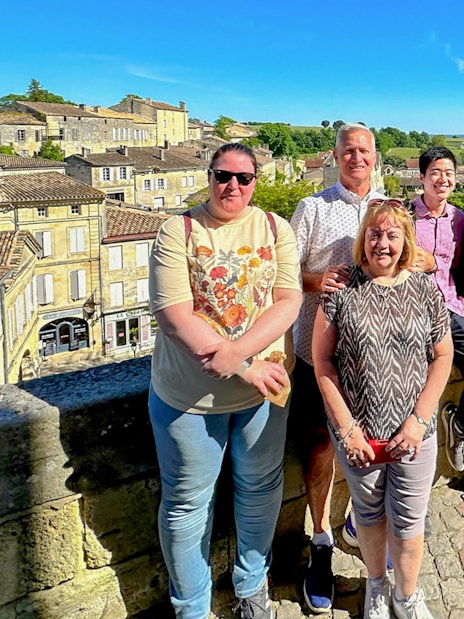 Group enjoying a tour in Saint Emilion with village and vineyard views.
