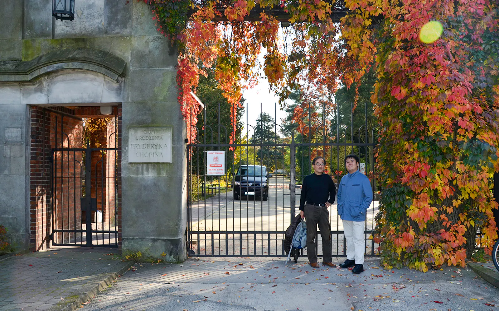 Entrance to Fryderyk Chopin's birthplace in Poland with autumn foliage.