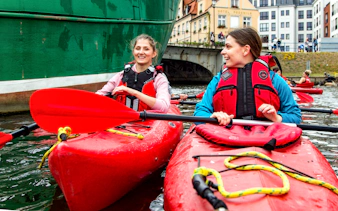 Kayakers paddling near historic buildings in Gdansk.
