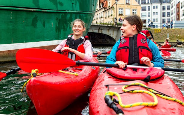 Kayakers paddling near historic buildings in Gdansk.