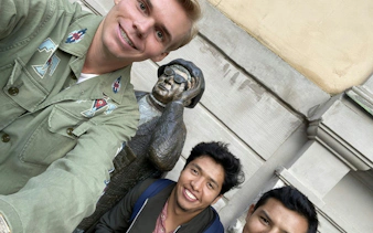 Visitors posing with a statue during The Troll Escape in Stockholm city exploration game.