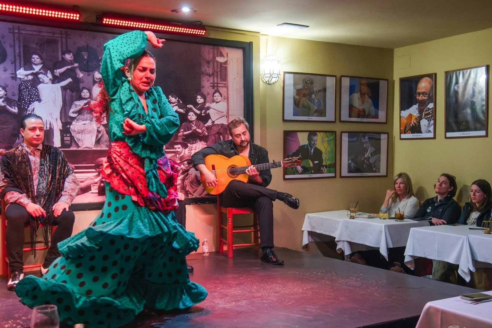 Flamenco dancers performing at Tablao La Cantaora, Seville with guitarist and audience.