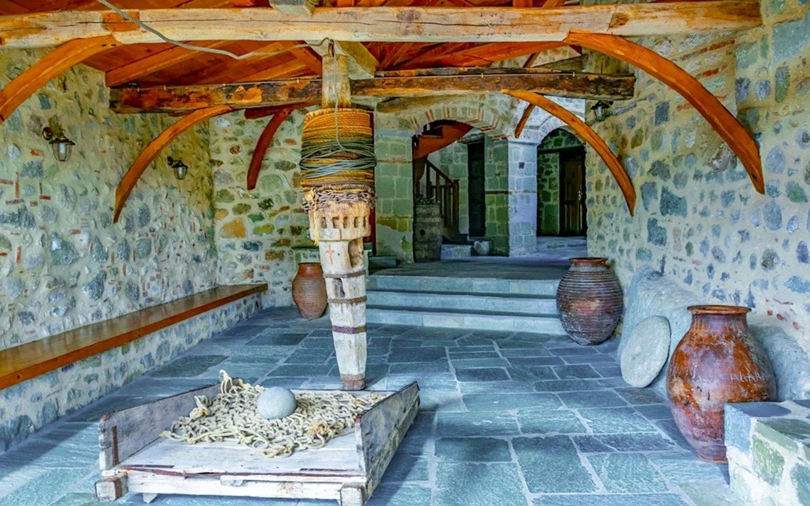 Monastery of the Holy Trinity at Meteora interior with stone walls and wooden beams.