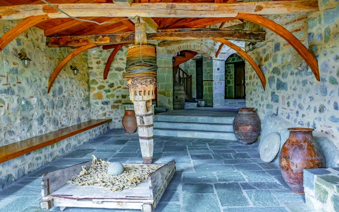 Monastery of the Holy Trinity at Meteora interior with stone walls and wooden beams.