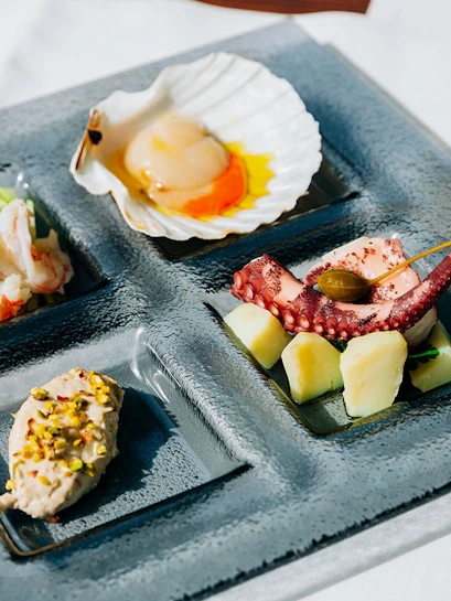 Venetian cicchetti platter with seafood and wine at illy Caffè, St. Mark's Square, Venice.