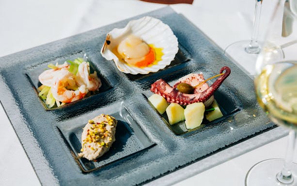 Venetian cicchetti platter with seafood and wine at illy Caffè, St. Mark's Square, Venice.