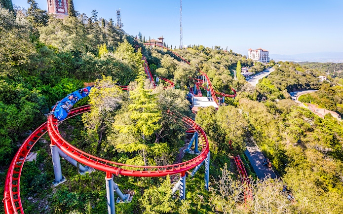 Roller coaster winding through trees at Tibidabo Amusement Park, Barcelona.
