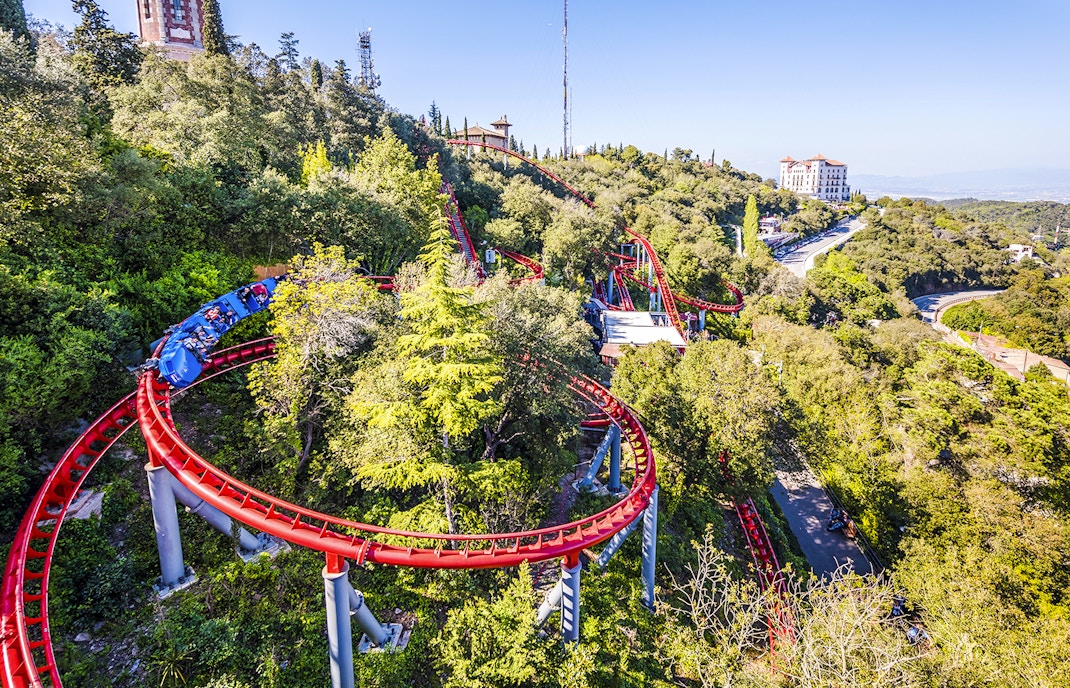 Roller coaster winding through trees at Tibidabo Amusement Park, Barcelona.