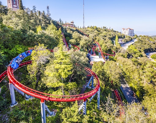 Roller coaster winding through trees at Tibidabo Amusement Park, Barcelona.