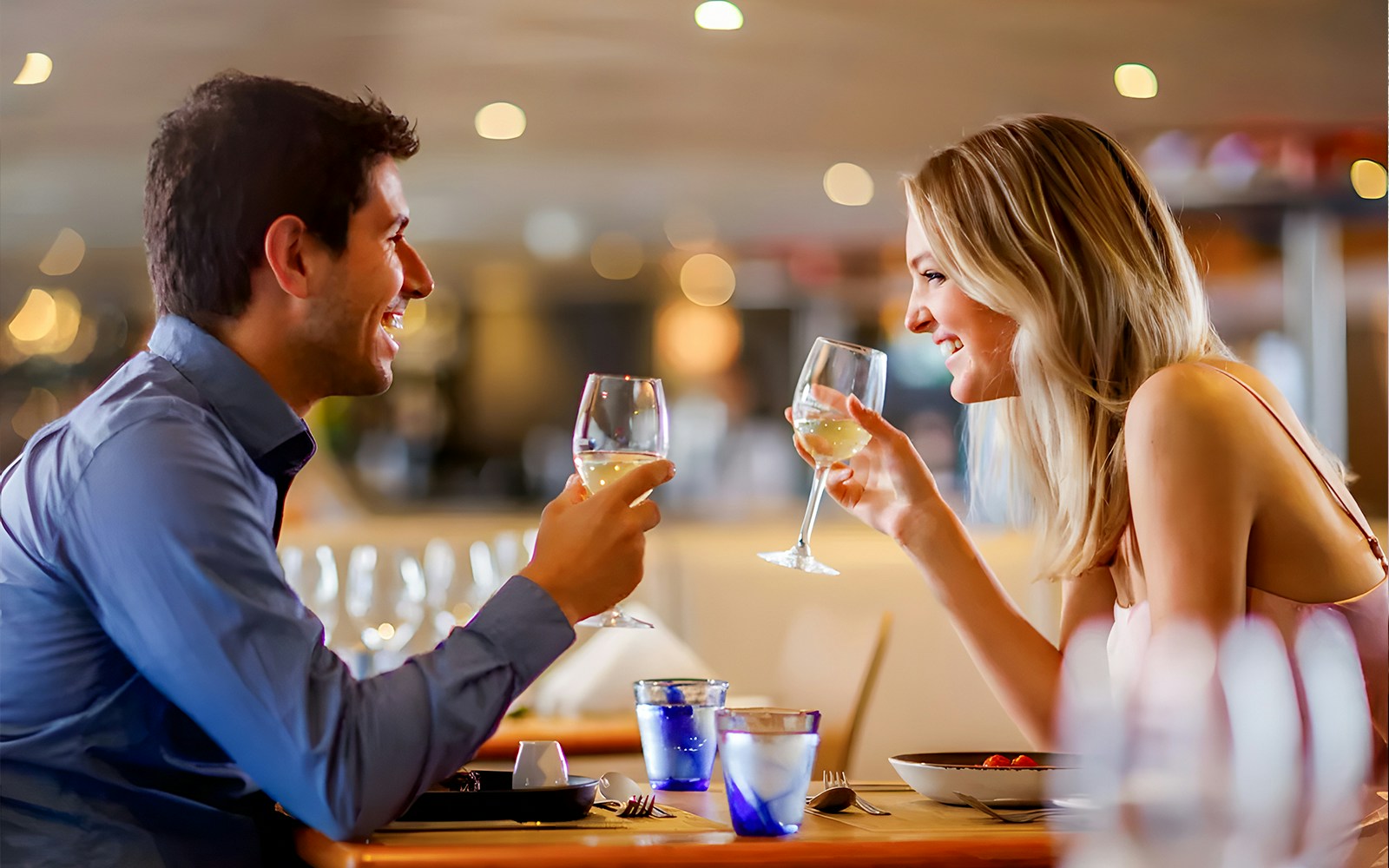 Couple dining on a Sydney Harbour cruise with city skyline in the background.