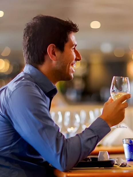 Couple toasting with wine on a Sydney Harbour dinner cruise.