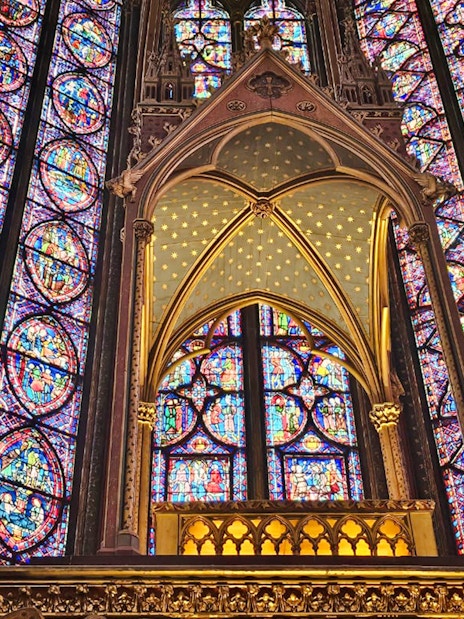 Stained glass windows inside Sainte Chapelle, Paris, showcasing intricate biblical scenes.