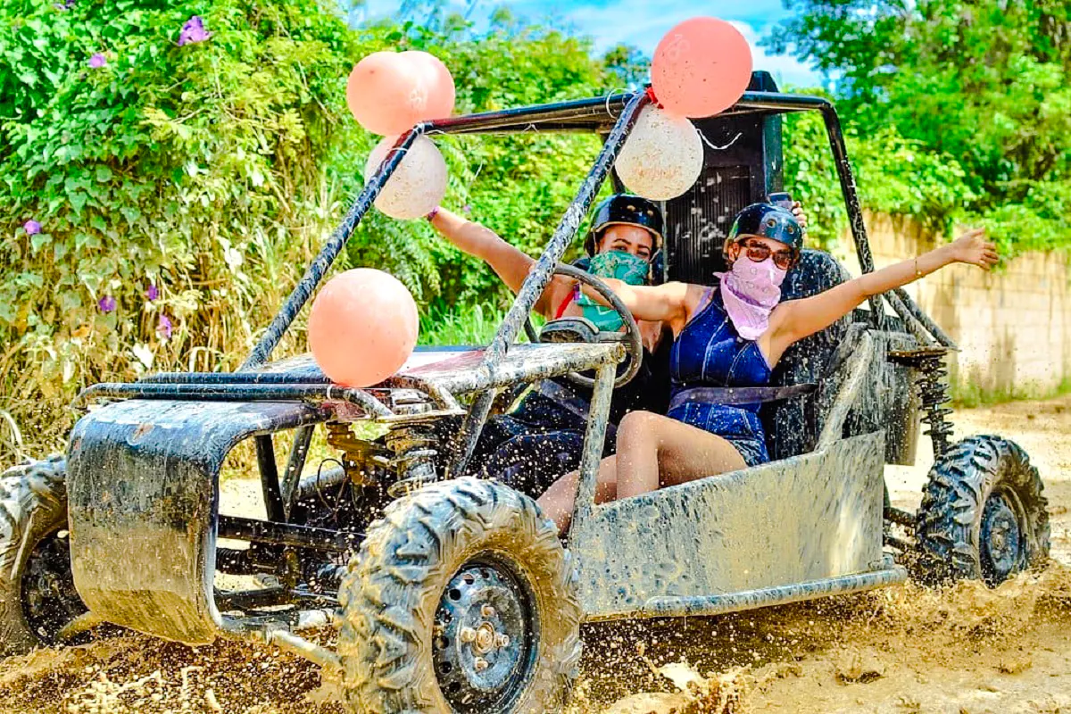 Two people driving a buggy through muddy trails in Punta Cana.