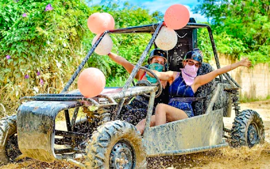 Two people driving a buggy through muddy trails in Punta Cana.