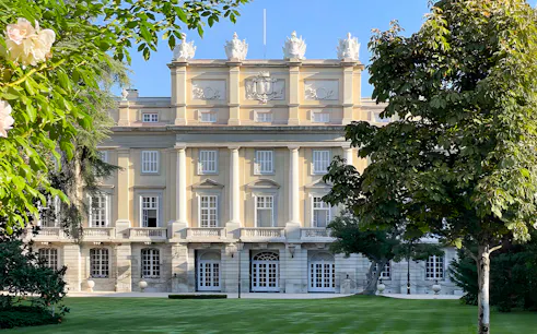 Liria Palace facade with neoclassical architecture in Madrid, surrounded by lush greenery.