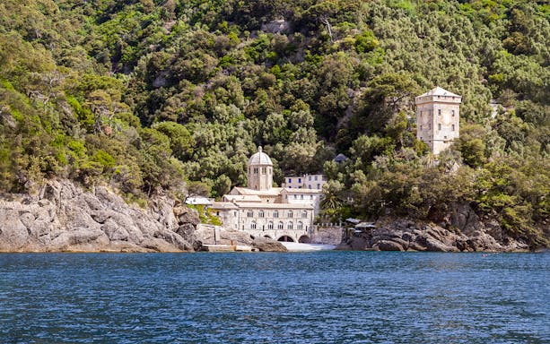Abbazia di San Fruttuoso nestled in lush hills by the sea, Liguria, Italy.