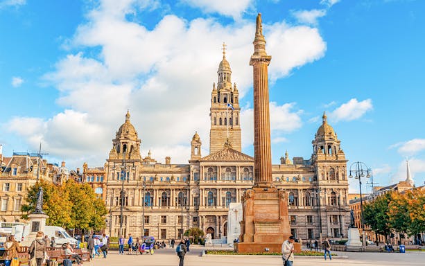 George Square in Glasgow with City Chambers and column statue, United Kingdom.