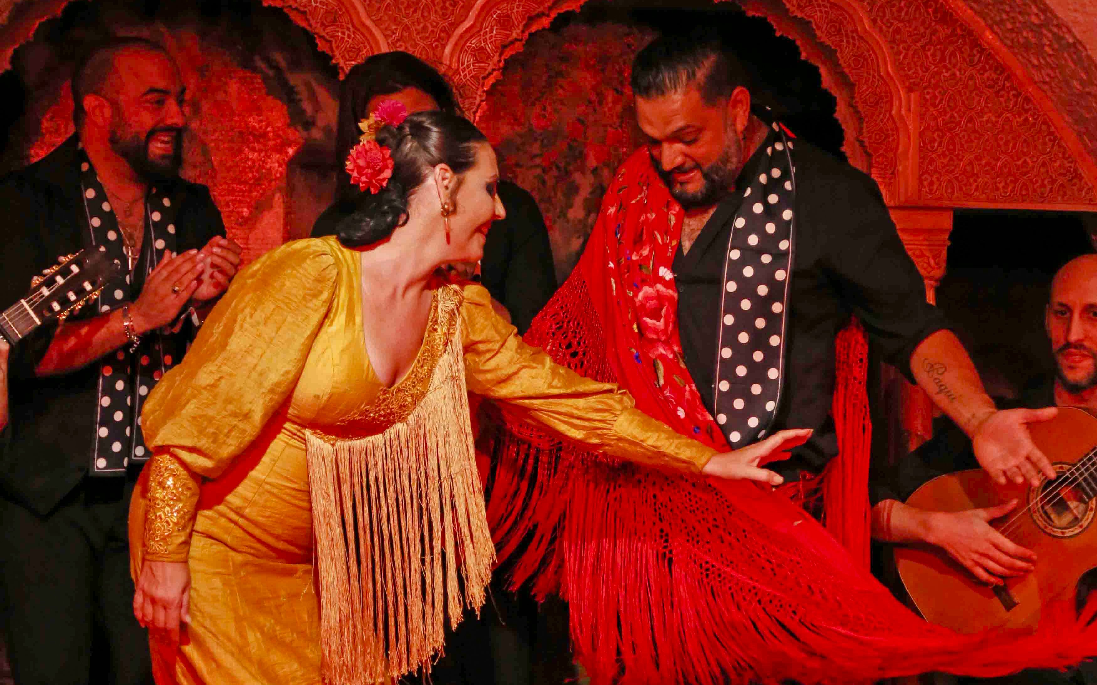Flamenco dancers performing at Tablao Cordobes in vibrant costumes.